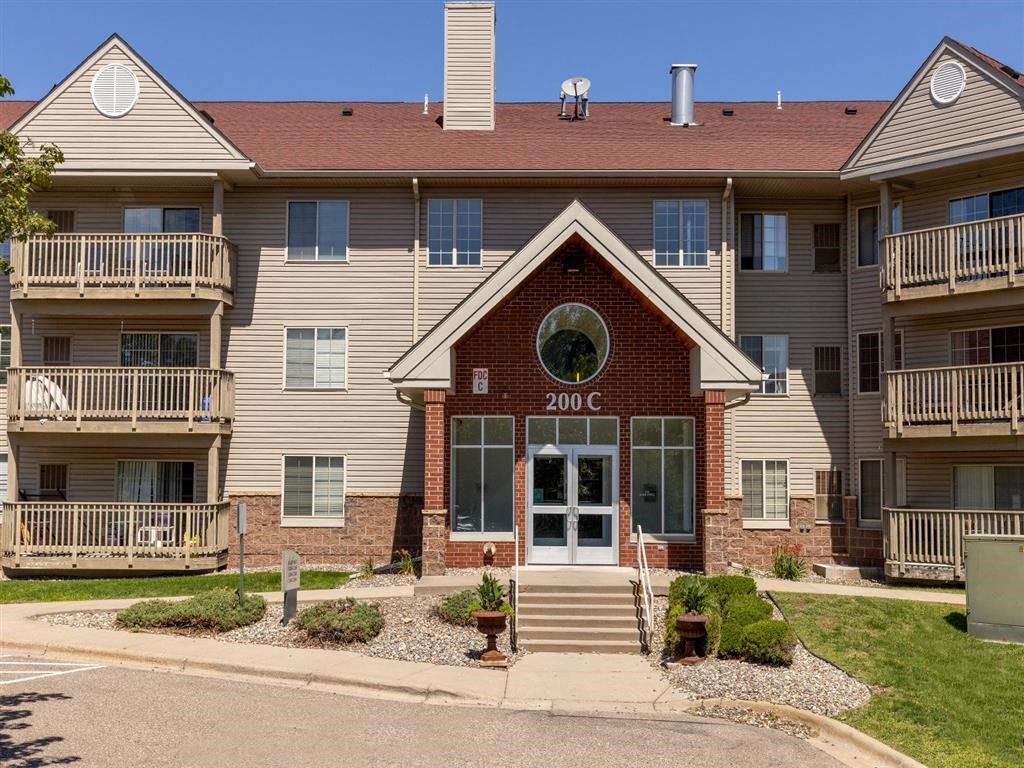 the front of an apartment building with stairs and a window