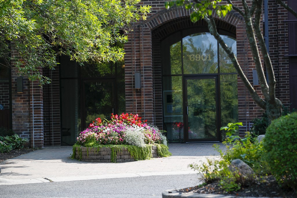 the front of a building with a flower garden in front of it
