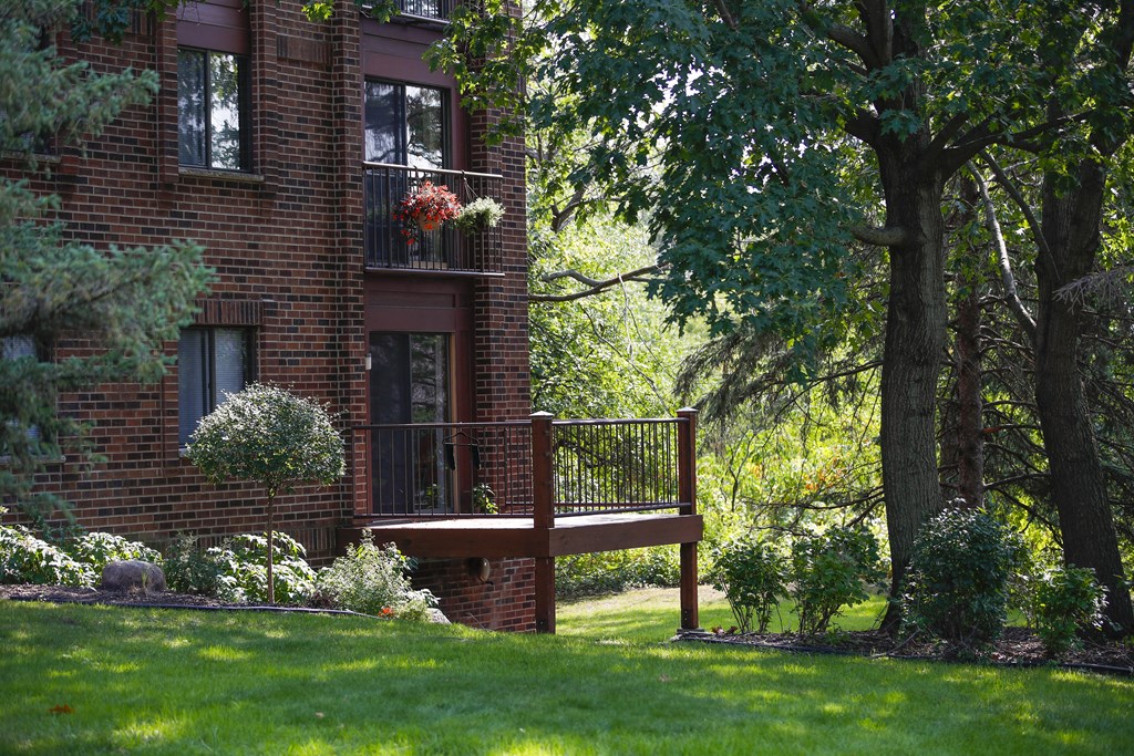 a wooden deck in front of a brick house