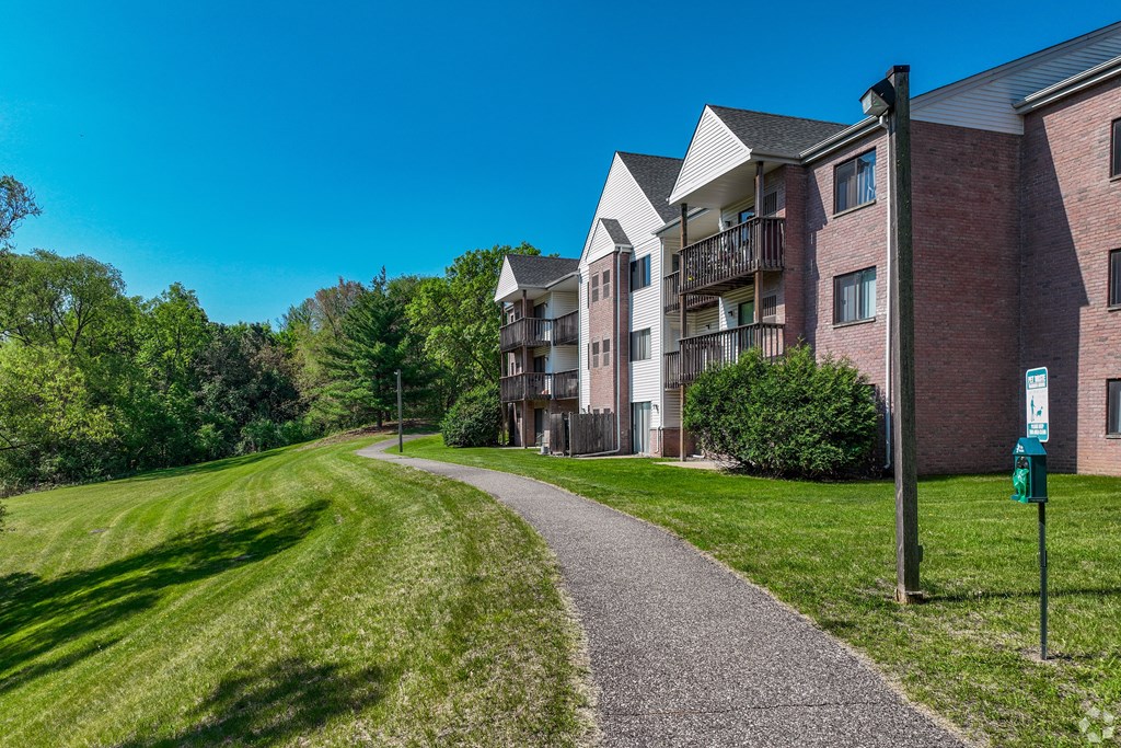 A pathway leads to a brick apartment building.