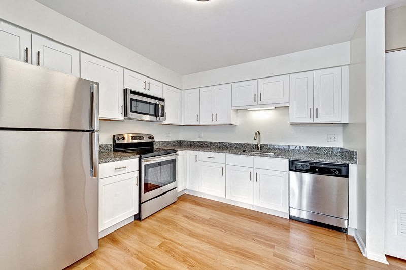 a kitchen with white cabinets and stainless steel appliances