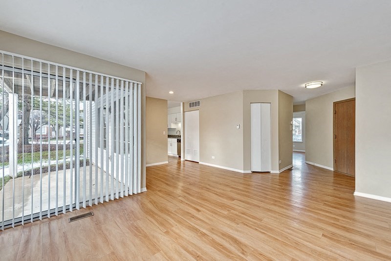 an empty living room with a wood floor and a window