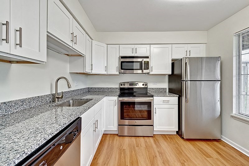 a kitchen with white cabinets and stainless steel appliances