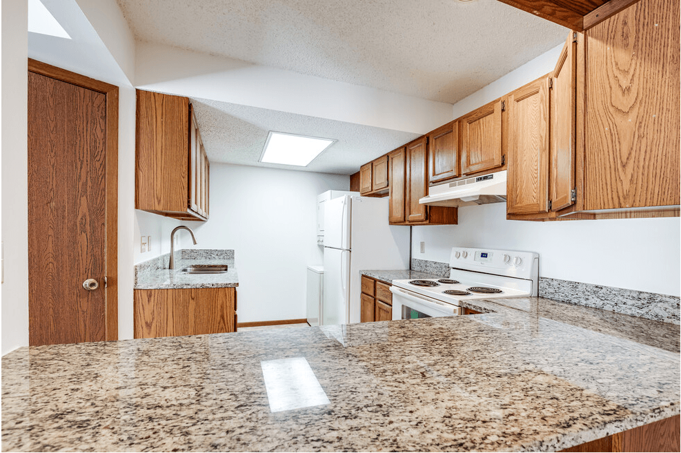 a kitchen with white appliances and granite counter tops