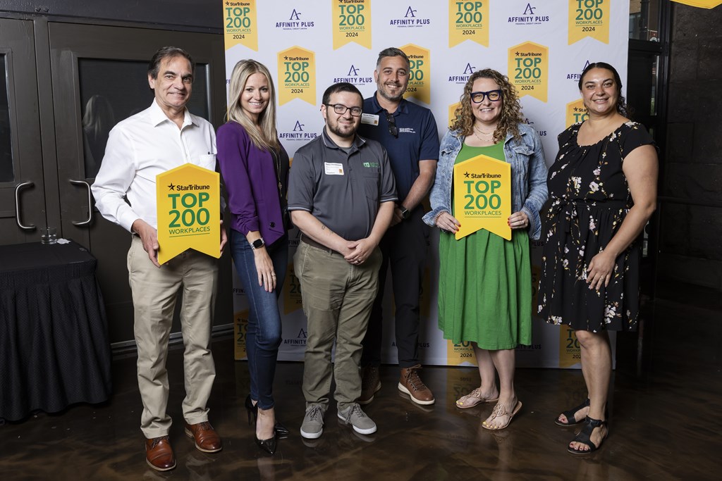 Six people stand in front of a banner that says "Top 200".