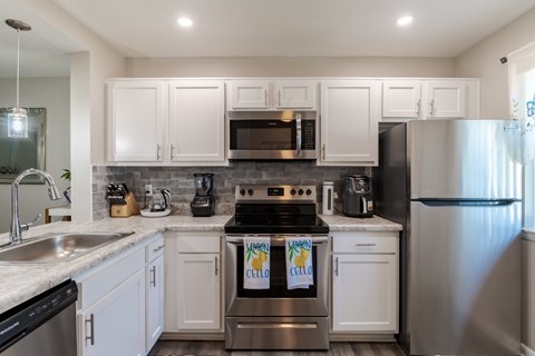 A kitchen with white cabinets and stainless steel appliances.