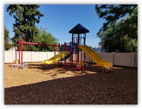 a playground with two slides and a swing set