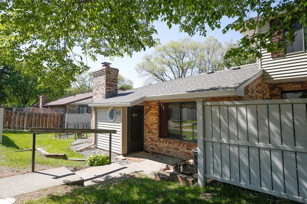 a view of the front of a house with a fence and a yard