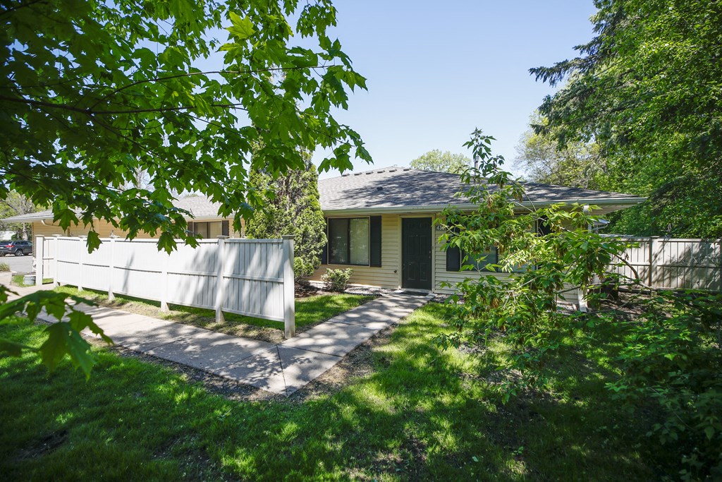 a green house with a fence in front of it