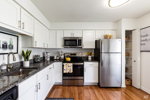 a kitchen with white cabinets and stainless steel appliances