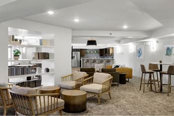 a living room with tables and chairs and a kitchen