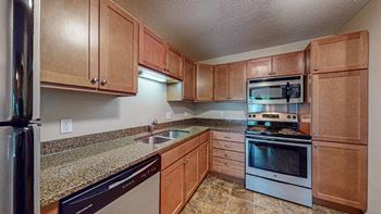 a kitchen with wooden cabinets and stainless steel appliances