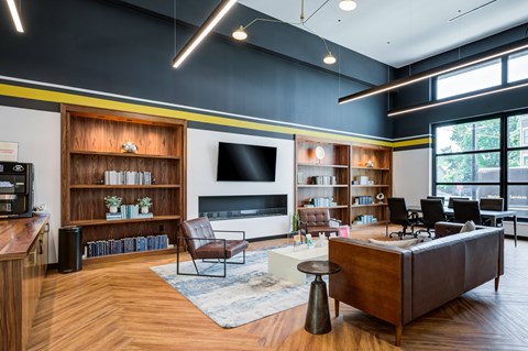 A living room with a brown leather couch and a wooden floor.