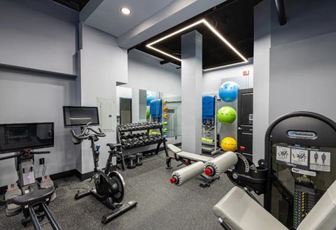 A gym with a variety of equipment including treadmills, stationary bikes, and weight machines.