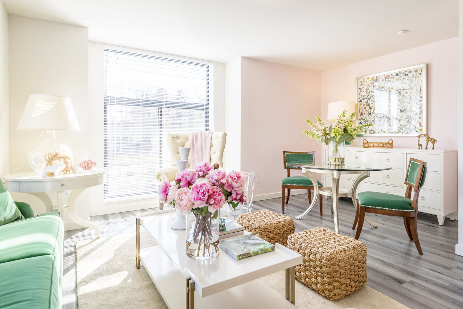 a living room with pink walls and a table with a vase of flowers