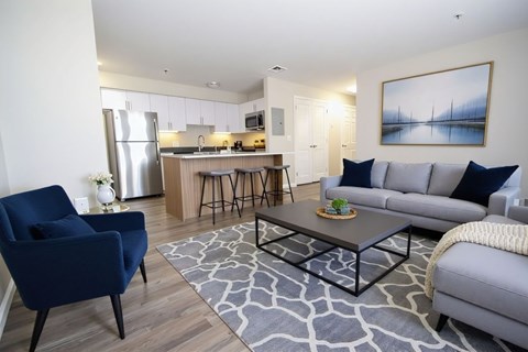 A modern living room with a blue chair and grey couch.