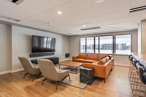 A living room with a television, two chairs, a sofa, and a coffee table.