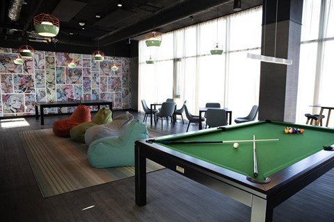 A pool table in a room with a patterned wallpaper.