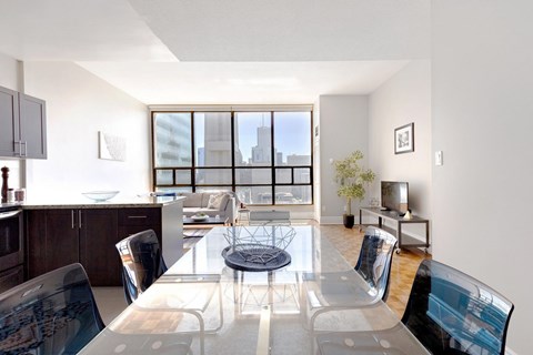A modern dining room with a glass table and chairs.