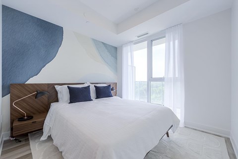 A bedroom with a large bed and a wooden headboard.