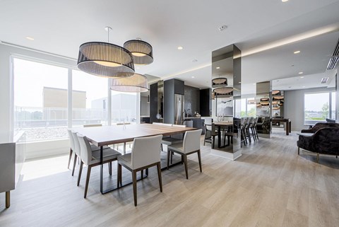 A modern dining room with a large table and chairs.