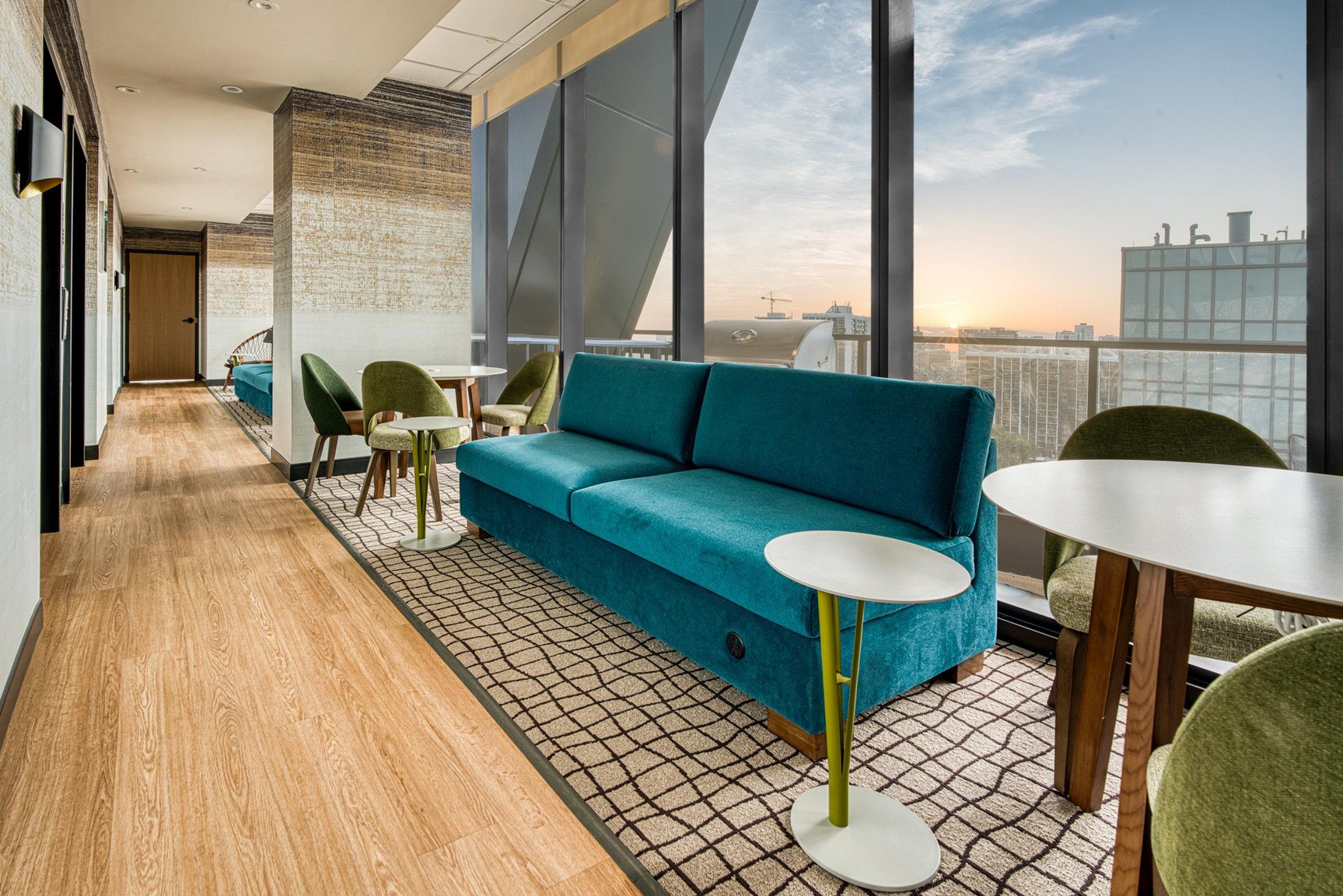 A long blue couch sits in a room with a table and chairs.