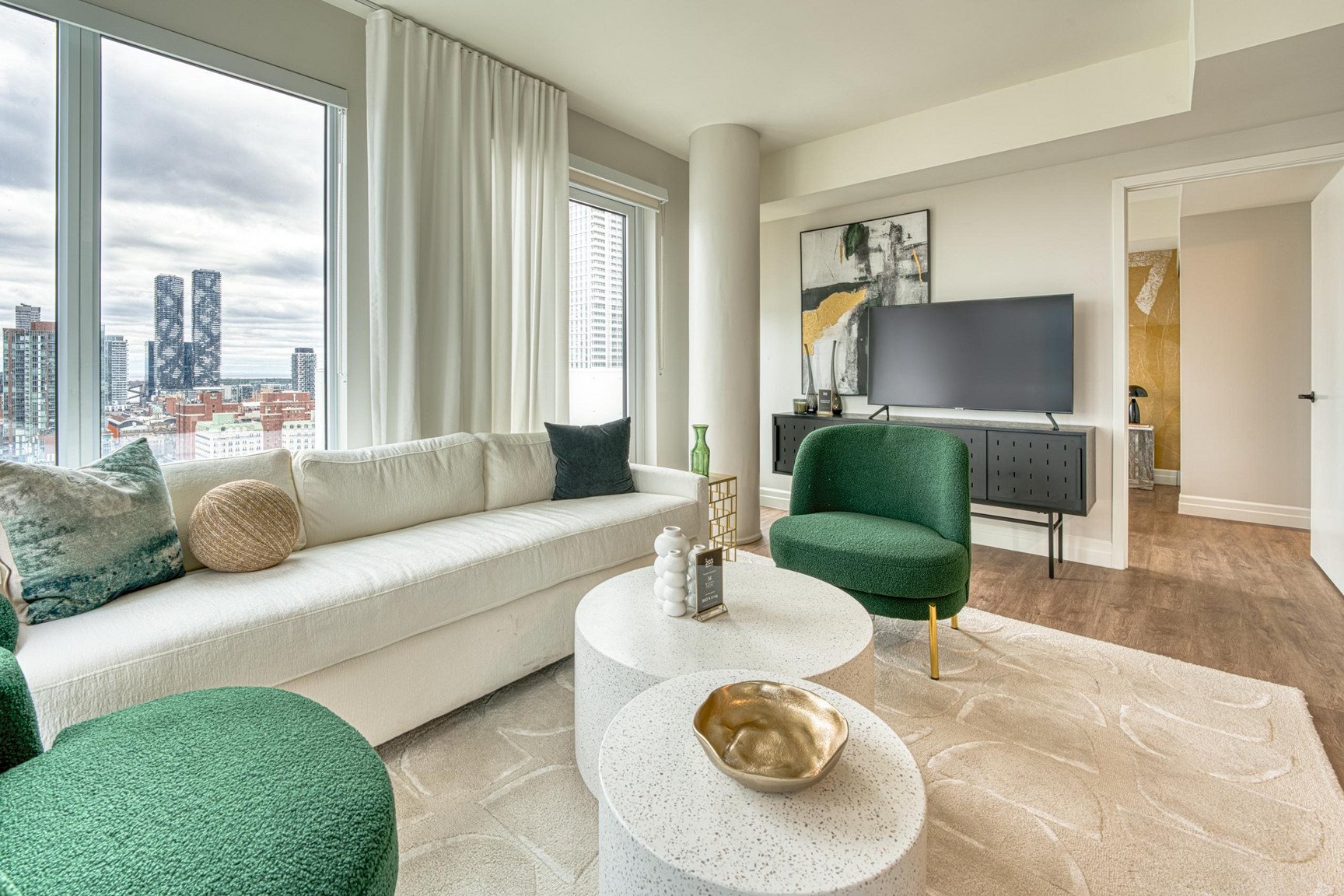 A living room with a white sofa, green armchair, and a white coffee table.