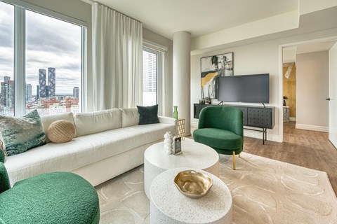 A living room with a white sofa, green armchair, and a white coffee table.