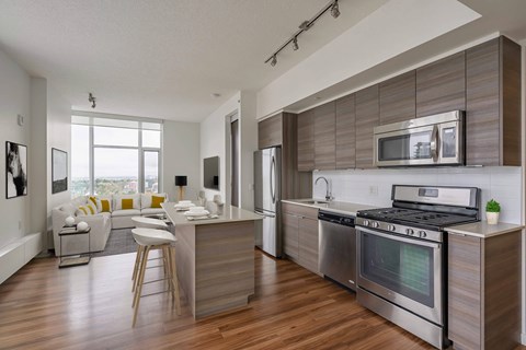 A modern kitchen with a wooden floor and stainless steel appliances.