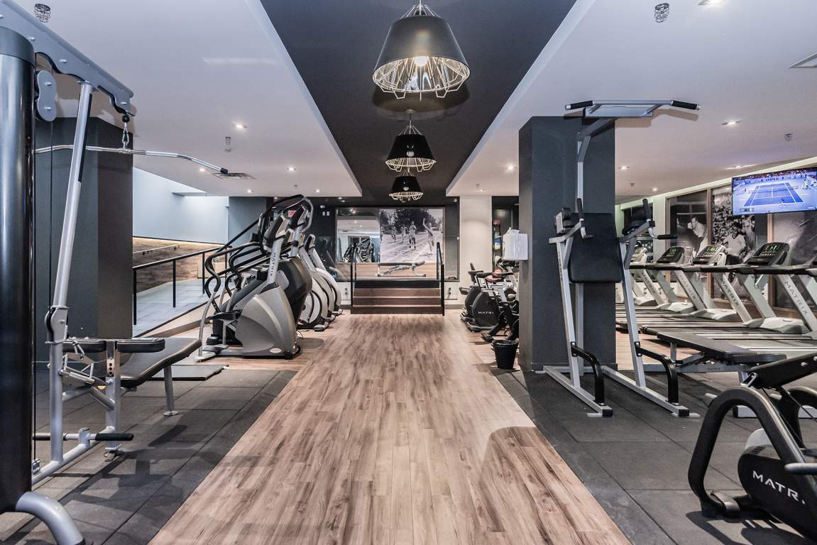 A gym with a variety of equipment including treadmills, weights, and exercise machines.