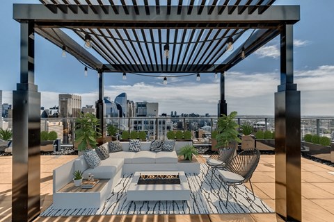 A patio with a white couch and a fire pit.