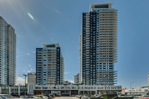 Three tall buildings are in the foreground with a clear blue sky above them.