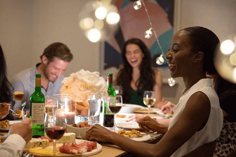A group of people enjoying a meal together at a dinner party.