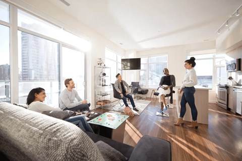 A group of people are gathered in a modern living room.