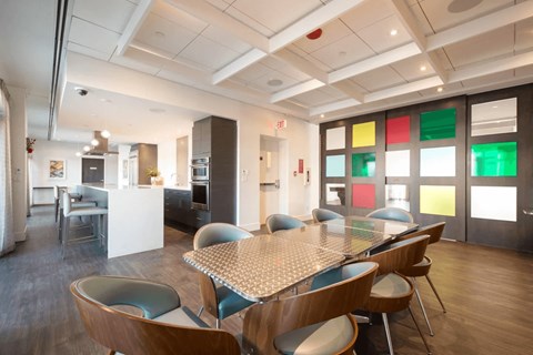 A modern dining room with a table surrounded by chairs.