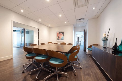 A conference room with a long table and chairs.