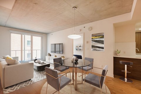 A modern dining room with a glass table and chairs.