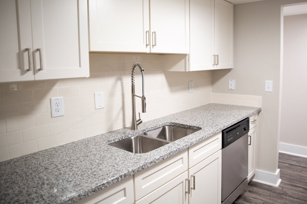 a kitchen with white cabinets and a sink and granite countertops