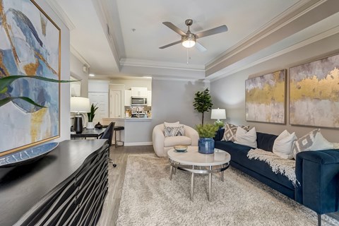 A living room with a blue couch and a ceiling fan.