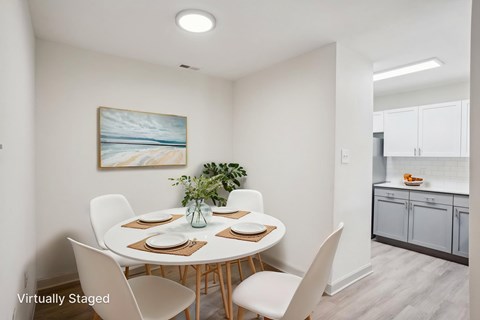 A dining room with a white table and chairs.