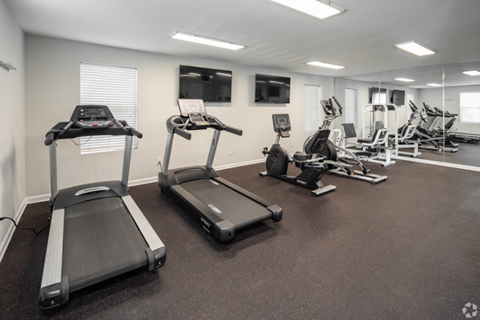 A gym with treadmills and other exercise equipment.
