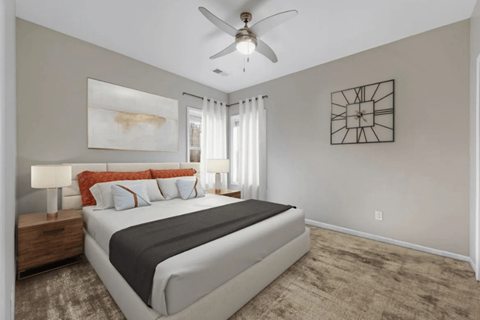A bedroom with a large bed and a ceiling fan.