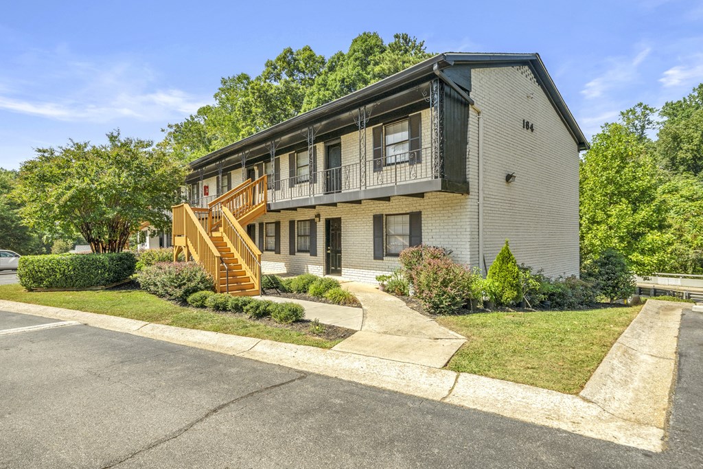 A two-story building with a balcony and a staircase.