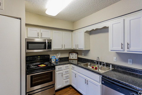 A kitchen with white cabinets and a black stove top.