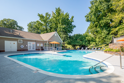 A large outdoor swimming pool with a building in the background.