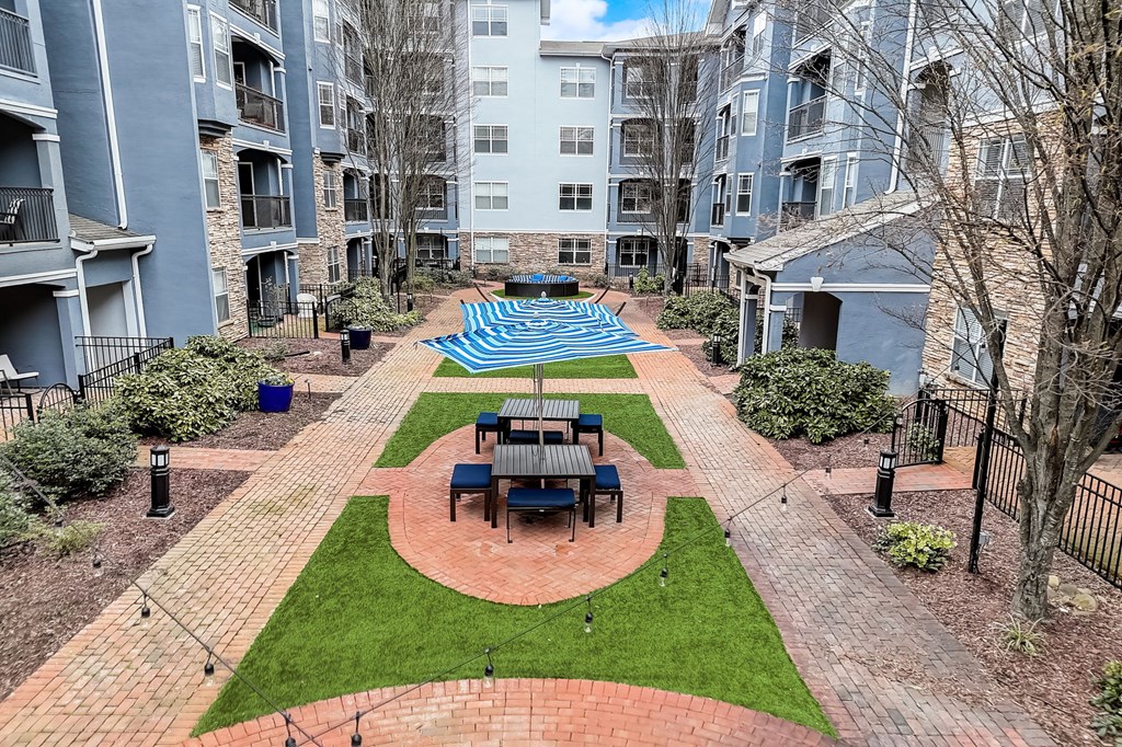 A courtyard with a table and chairs surrounded by apartment buildings.