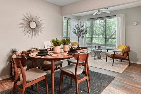 A dining room with a round table and chairs.
