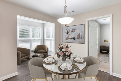 A dining room with a round table set for four.