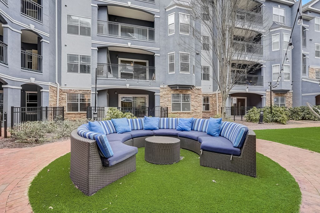 A grey building with a blue and white sofa in front.