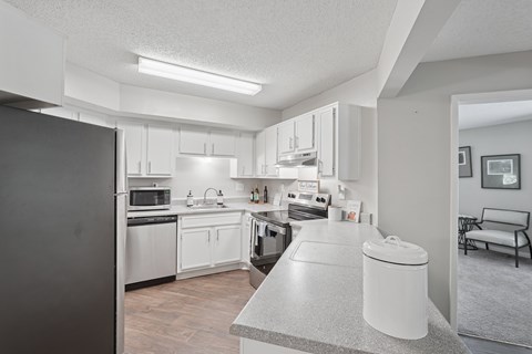 A modern kitchen with white cabinets and appliances.